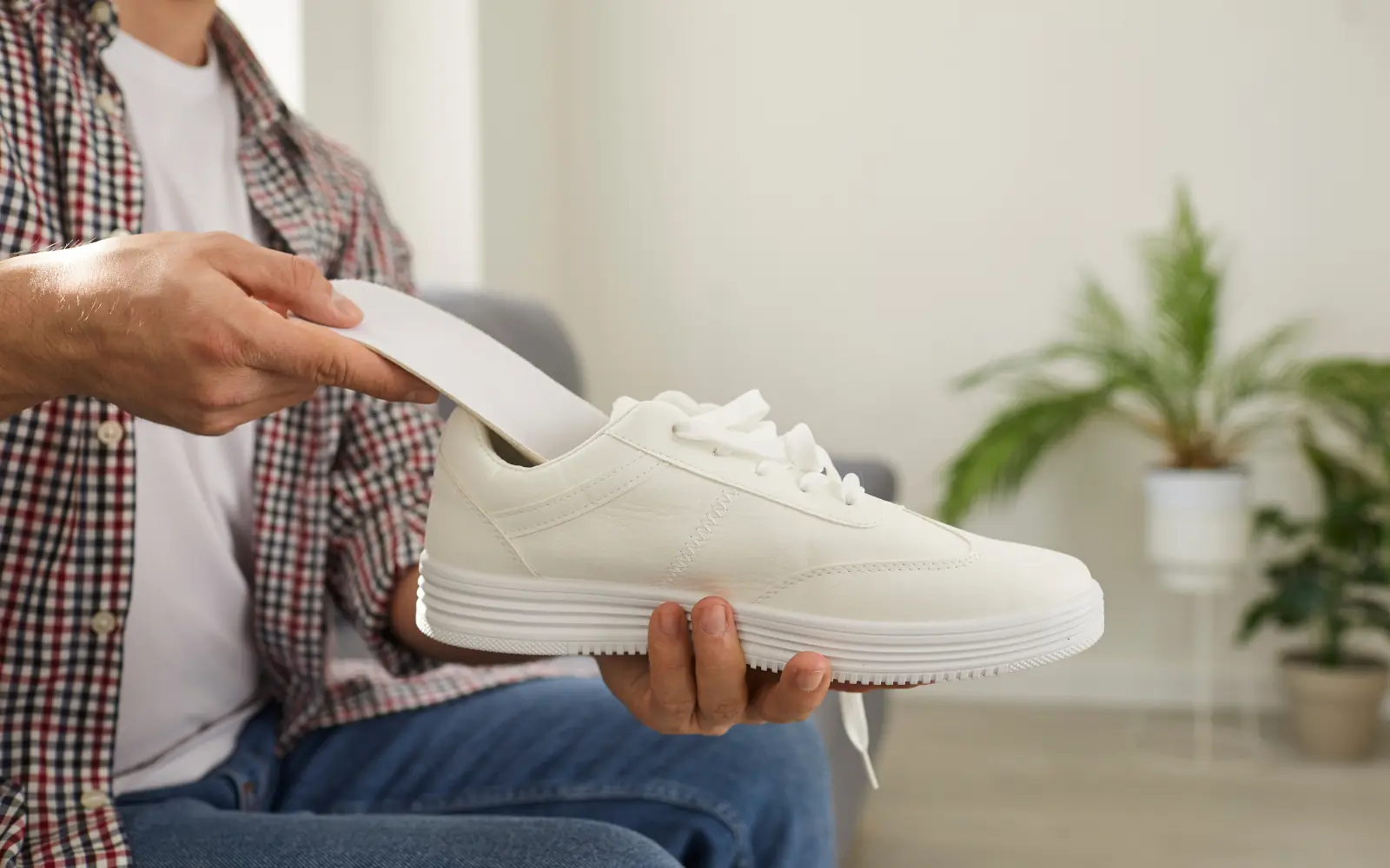 A contoured arch-support insole being fitted into a trainer, the prefab option for plantar fasciitis.